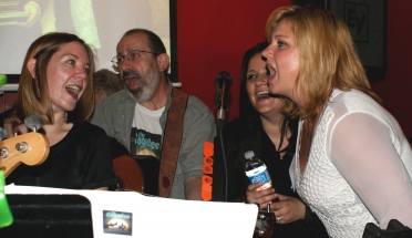 Peter with guitar with singing ladies