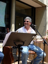 Burke sitting,smiling and playing bass